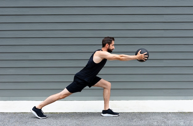 Allenamento uomo in forma vista laterale con palla