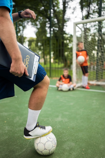 Allenatore di calcio che insegna ai suoi alunni