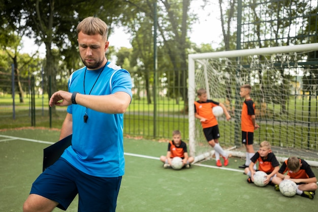 Allenatore di calcio che insegna ai suoi alunni