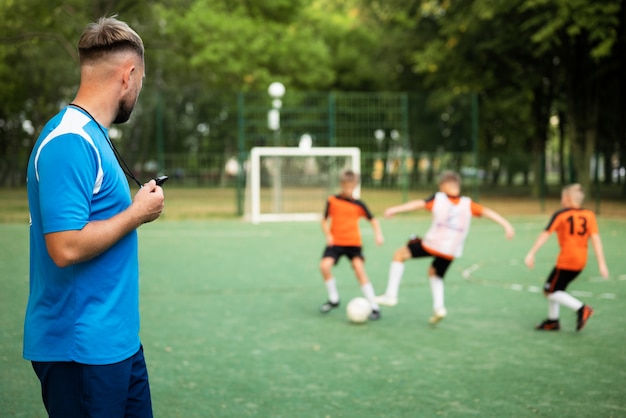 Allenatore di calcio che insegna ai suoi alunni