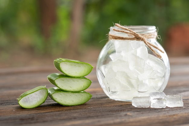 Aloe Vera sullo sfondo del bancone in legno dell'esposizione del prodotto. l'aloe vera è una pianta verde tropicale. Cosmetici naturali di rinnovamento organico di Aloe Vera affettati, medicina alternativa. Concetto di cura della pelle organica.