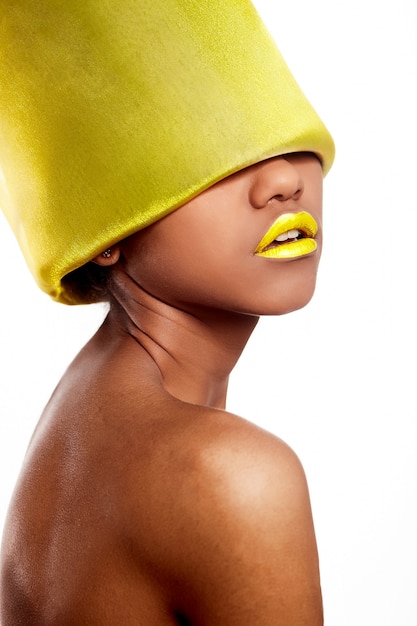 Alta moda look.glamour moda bella donna americana nera con labbra luminose gialle con materiale giallo sulla testa isolata su bianco