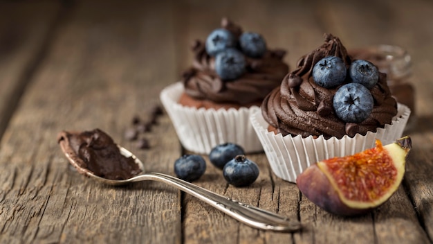 Alta vista gustoso cupcake e cucchiaio con crema al cioccolato