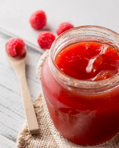 Alto angolo del barattolo di vetro con marmellata di lamponi