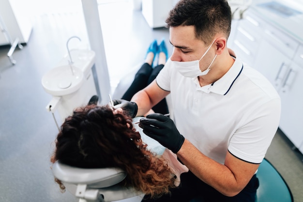 Alto angolo del dentista che esegue un controllo sul paziente