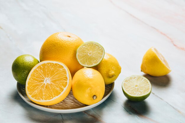 Alto angolo del piatto con il limone su fondo di marmo