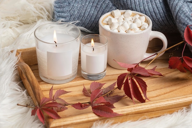 Alto angolo del vassoio con candele e tazza di cioccolata calda con marshmallow