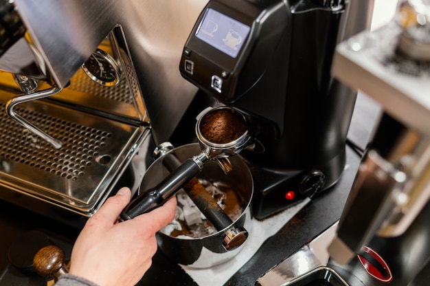 Alto angolo di barista maschio utilizzando macchina da caffè professionale