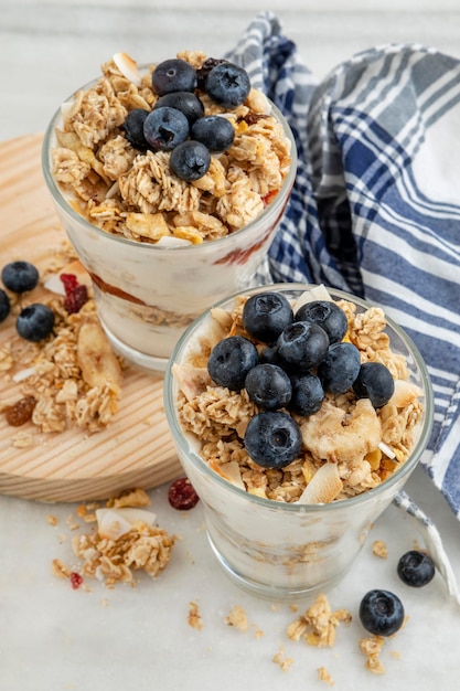 Alto angolo di bicchieri con cereali per la colazione e yogurt con frutta