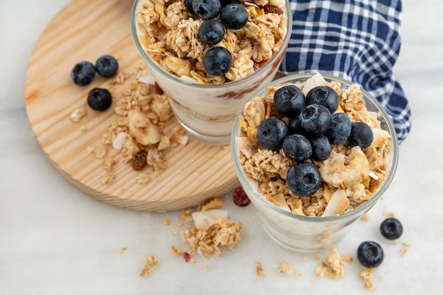 Alto angolo di bicchieri con cereali per la colazione e yogurt