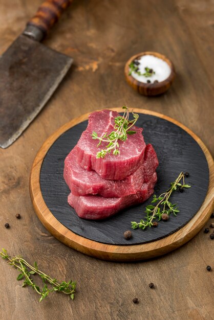 Alto angolo di carne impilata con erbe e sale