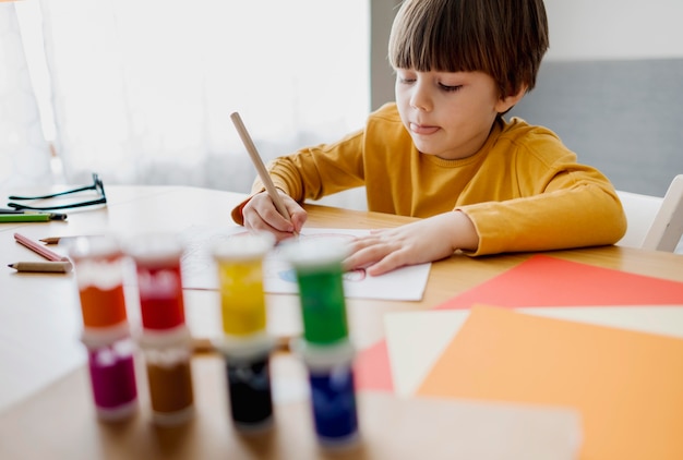 Alto angolo di disegno del bambino e di apprendimento a casa