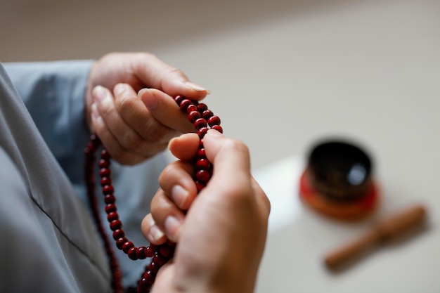 Alto angolo di donna che tiene perline e meditando