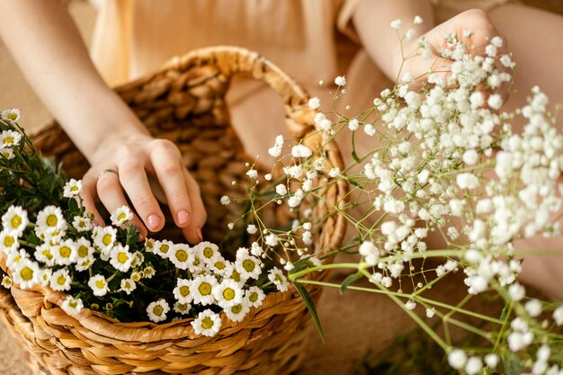 Alto angolo di donna con cesto di fiori primaverili