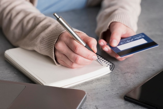 Alto angolo di donna con notebook e carta di credito