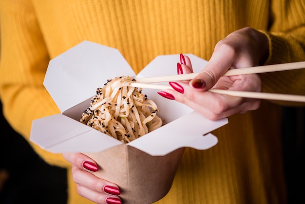 Alto angolo di donna con scatola di noodles