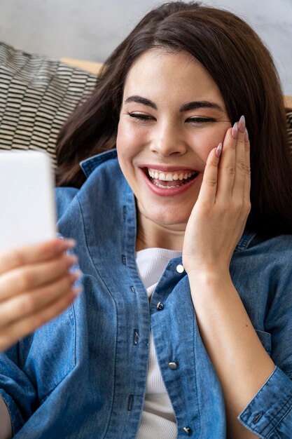 Alto angolo di donna felice sorridente e prendendo un selfie