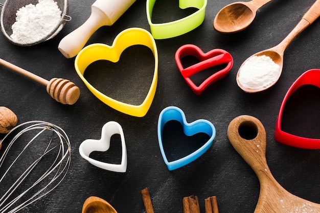 Alto angolo di forme colorate di cuore con utensili da cucina