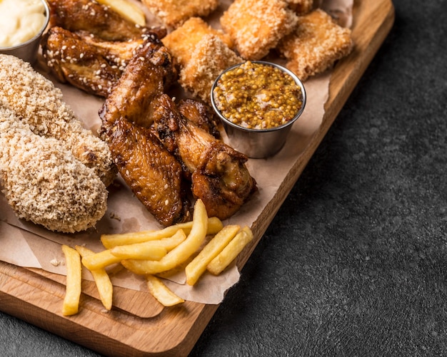 Alto angolo di patatine fritte con pollo fritto e pepite