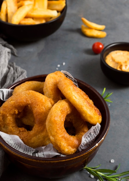 Alto angolo di patatine fritte in una ciotola con le erbe