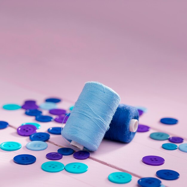 Alto angolo di pulsanti blu e bobine di filo con spazio di copia