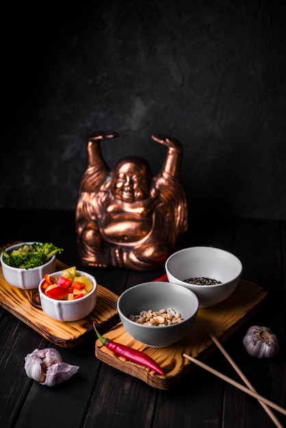 Alto angolo di tazze di verdure con statua
