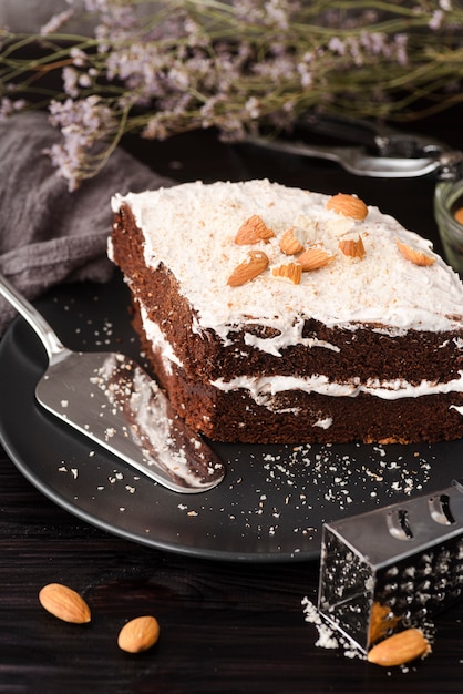 Alto angolo di torta sul piatto con mandorle e grattugia