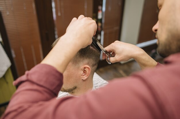 Alto angolo di uomo che ottiene un taglio di capelli