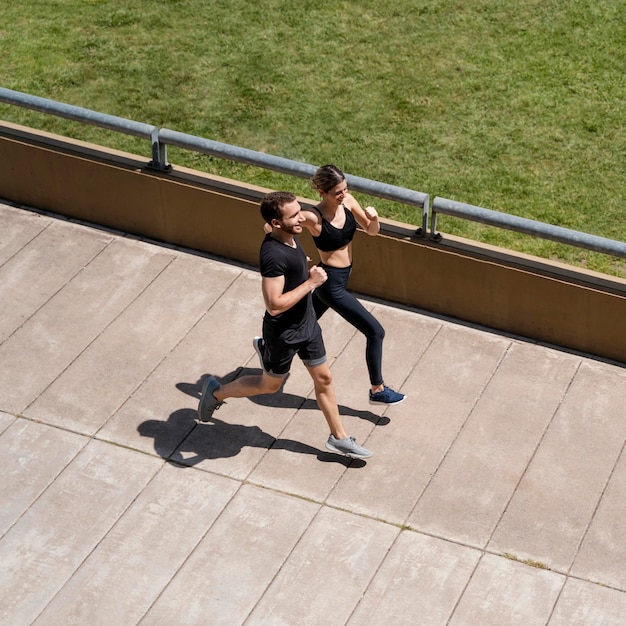 Alto angolo di uomo e donna che fanno jogging insieme all'aperto