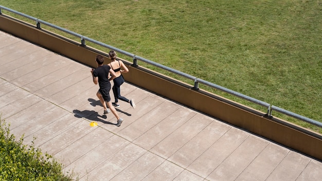 Alto angolo di uomo e donna che fanno jogging insieme all'esterno