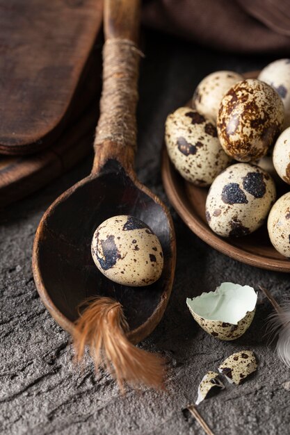 Alto angolo di uova di Pasqua con gusci rotti e cucchiaio di legno