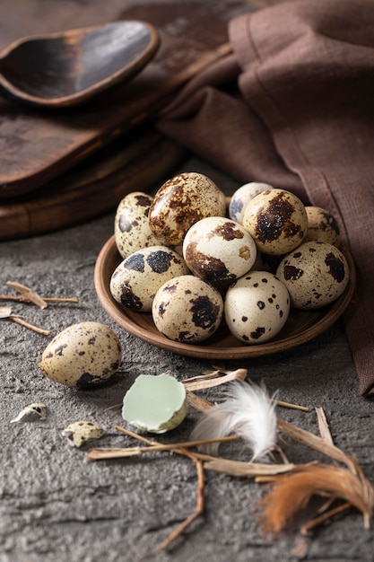 Alto angolo di uova di Pasqua sul piatto con tessuto e cucchiaio di legno