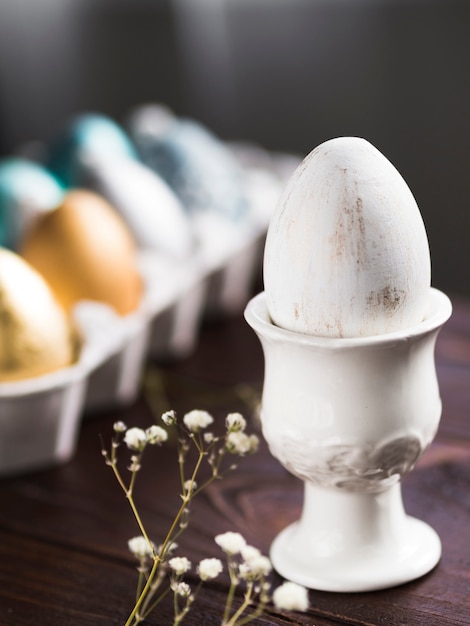 Alto angolo di uovo di Pasqua colorato su supporto con gypsophila