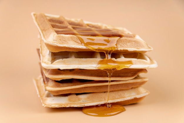 Alto angolo di waffle con miele gocciolante