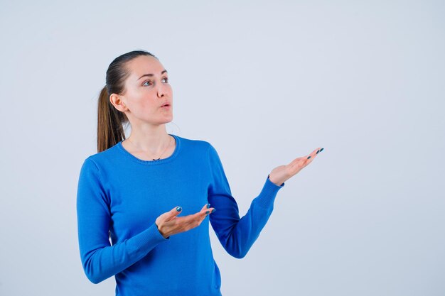 Alzando lo sguardo la ragazza sta puntando lì con le mani su sfondo bianco