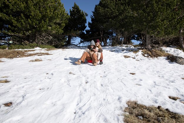 Amanti femminili su una slitta durante il loro viaggio invernale