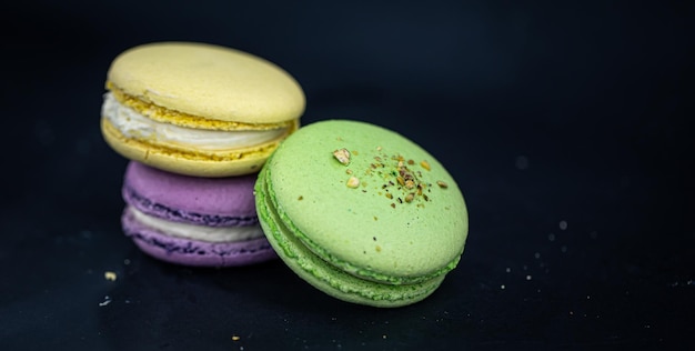 Amaretti francesi dolci e colorati o macaron su sfondo nero