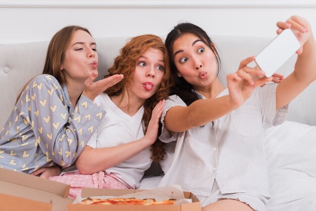 Amiche che prendono i selfie durante la festa del pijama