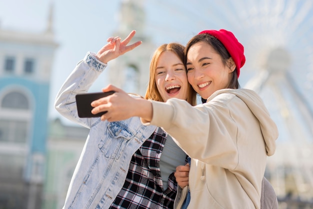 Amiche che prendono selfie con l'occhio di Londra