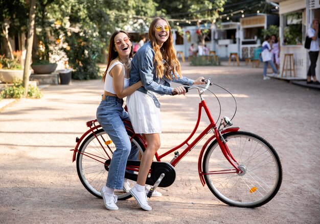 Amiche di vista laterale che guidano insieme bici