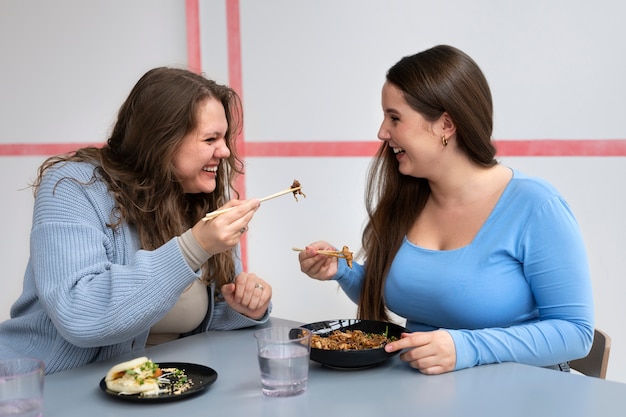 Amiche taglie forti trascorrono del tempo insieme in un ristorante