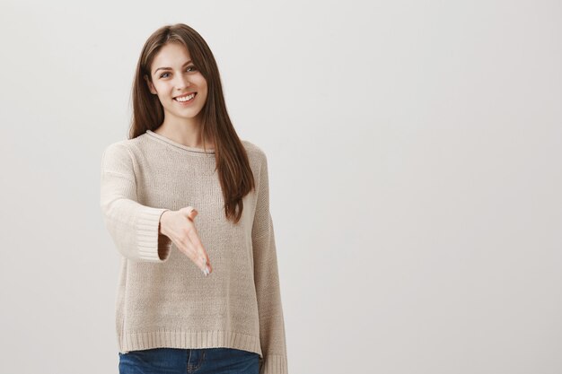 Amichevole donna sorridente saluto persona con la stretta di mano