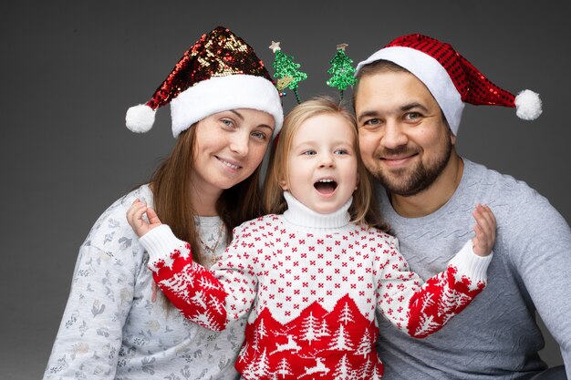 Amichevole famiglia di tre persone in piedi insieme e sorridenti