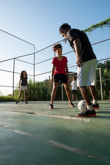 Amici a tutto campo che giocano a calcio