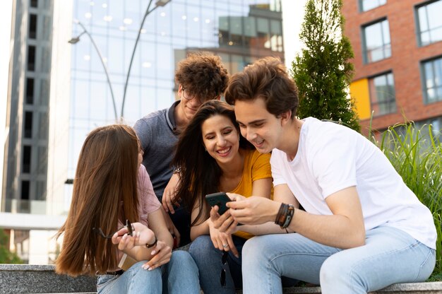 Amici all'aperto in città guardando smartphone