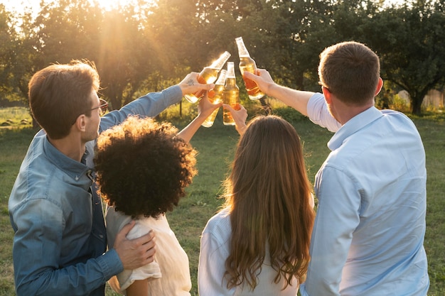 Amici all'aperto nel parco che bevono birra insieme