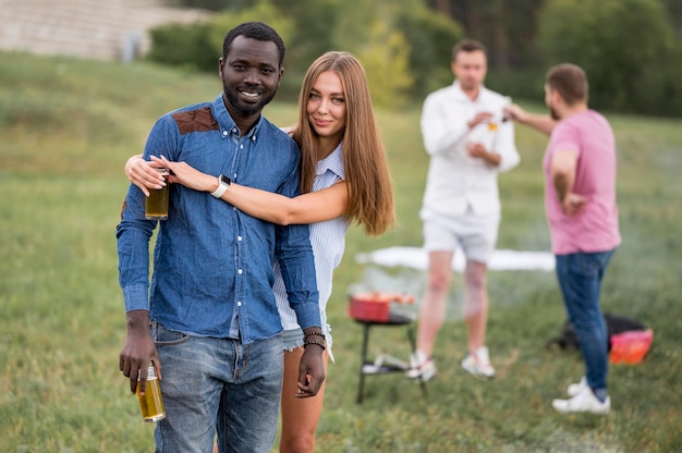 Amici che abbracciano a un barbecue