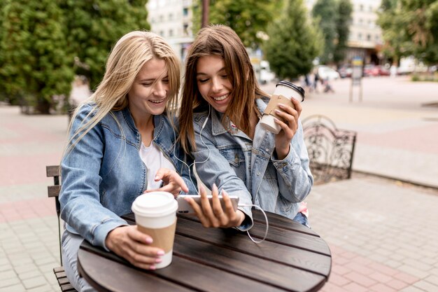 Amici che ascoltano musica mentre tengono alcune tazze di caffè