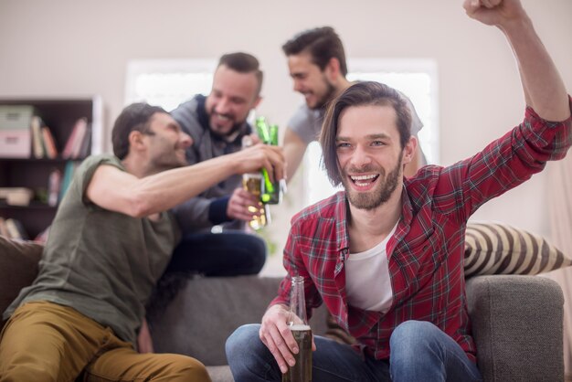 Amici che bevono birra e guardano la partita di calcio