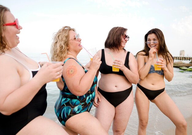 Amici che bevono succo alla vista lunga della spiaggia